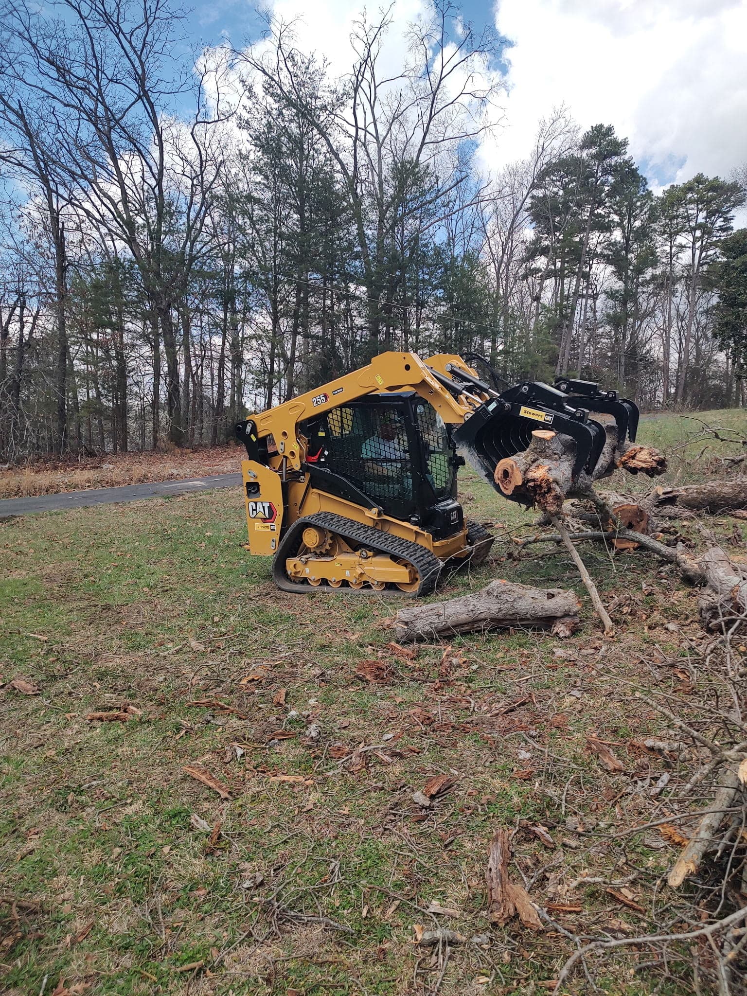 Bobcat skid-steer clearing logs during a tree removal